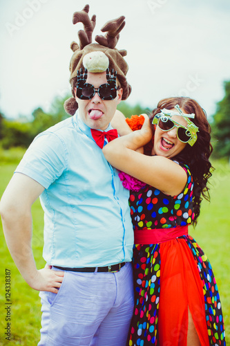 Funny picture of groomsman in deer hat and bridesmaid in sunglas photo