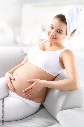 Ciężarna kobieta.
Piękna uśmiechnięta młoda kobieta w ciąży.
