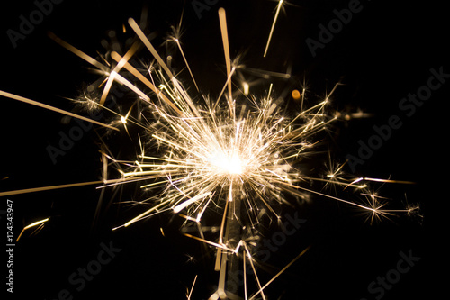 Burning sparkler isolated on black background