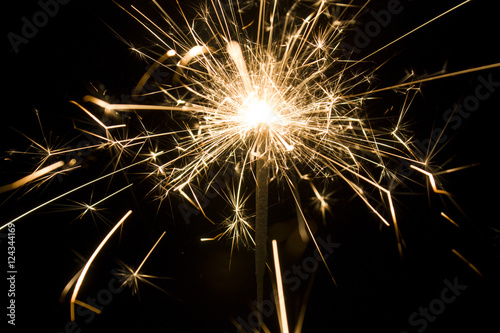 Burning sparkler isolated on black background