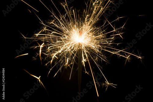 Burning sparkler isolated on black background