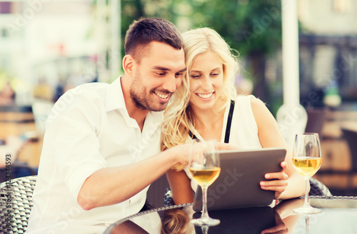 happy couple with tablet pc at restaurant lounge