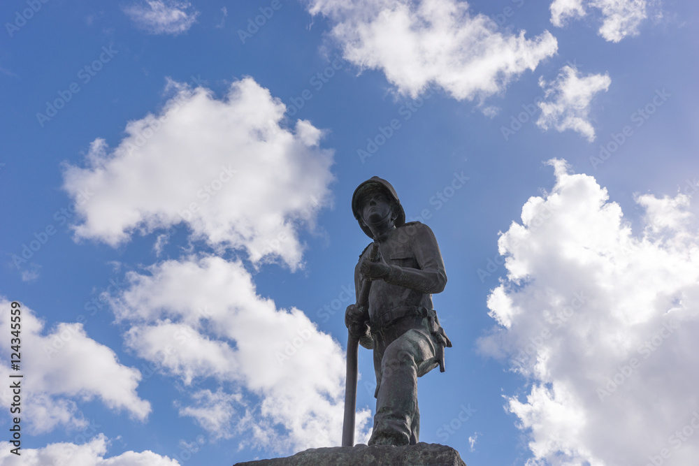 Firefighter statue with blue sky and clouds in the background
