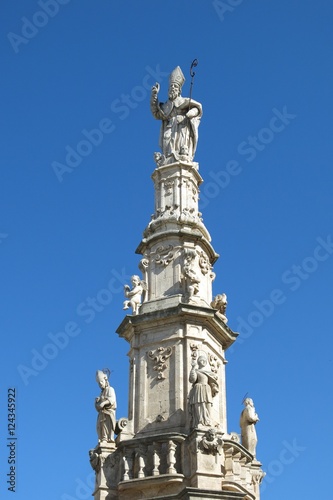 Statue of Saint Oronzo in Ostuni, Italy. Saint Oronzo is credited with protecting Ostuni from an 18th century famine. The statue stands atop a spire erected in 1771.   © Amy Laughinghouse