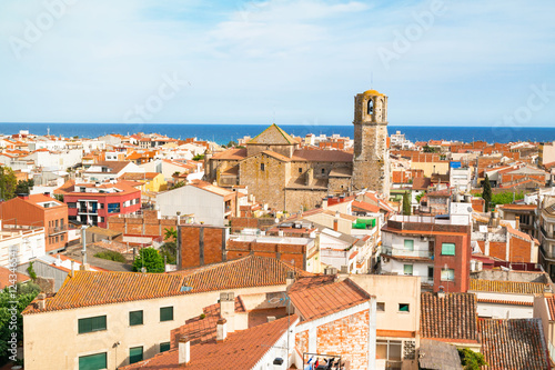 View over the roofs of old town Malgrat de Mar (Spain) from the hill with Mediterranean sea in the background and the Cathedral of the Coast in the middle