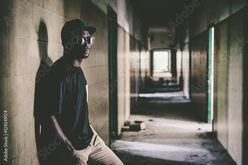 African man leaning on wall on hallway photo