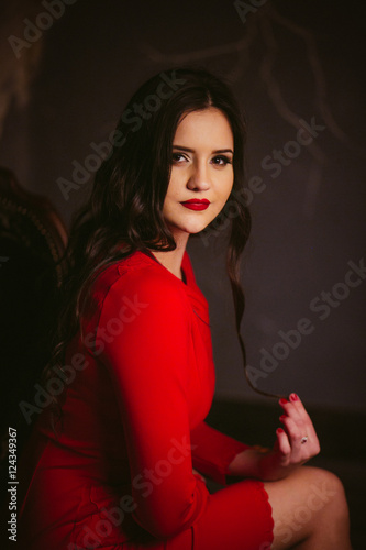 amazing lady  in red dress sitting on a chair