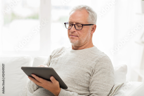 senior man with tablet pc at home