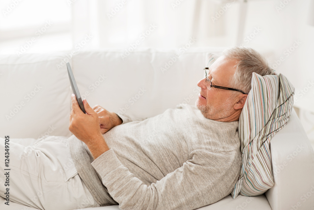 senior man with tablet pc lying on sofa at home senior man with tablet pc lying on sofa at home