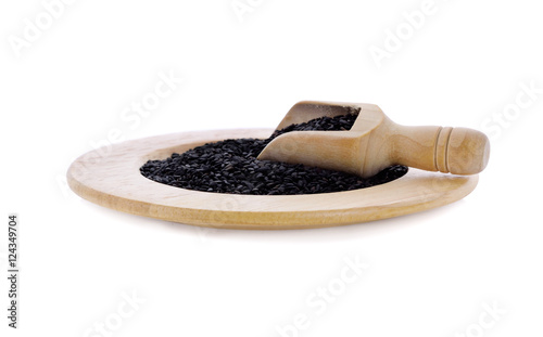 black sesame in wood scoop and wooden plate on white backgroun