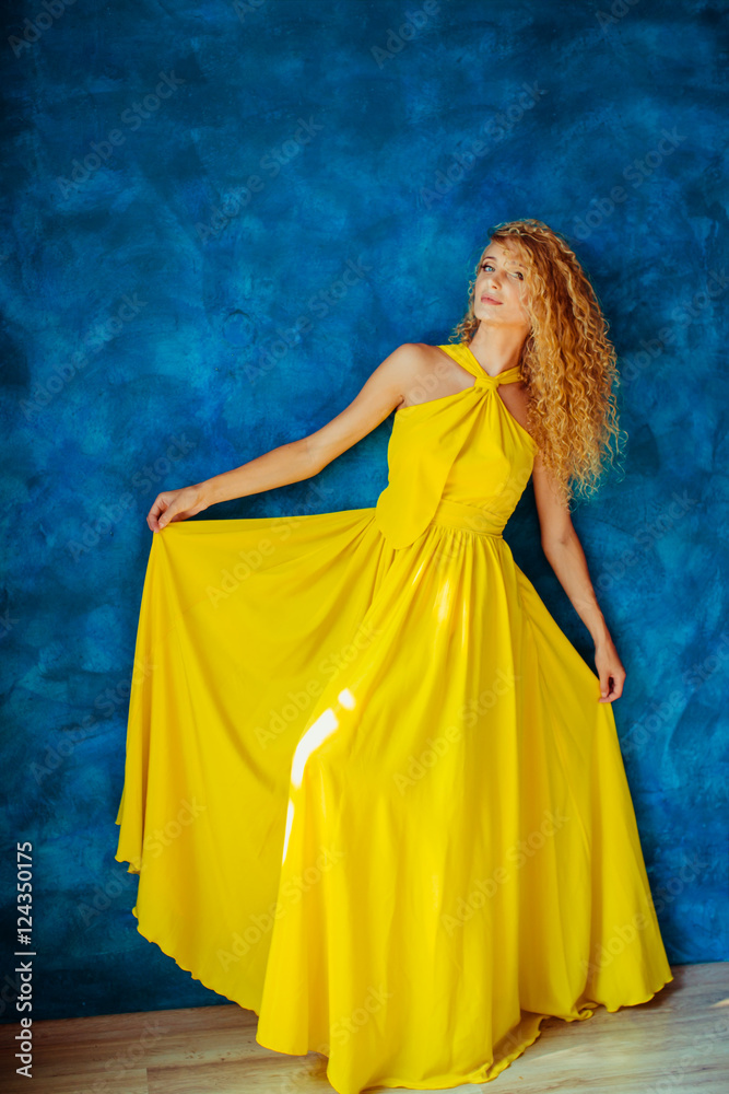 woman in a yellow dress looks at photographer