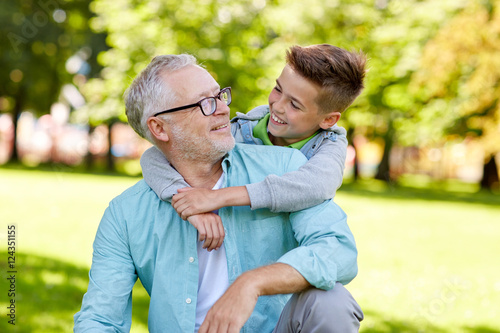 grandfather and grandson hugging at summer park