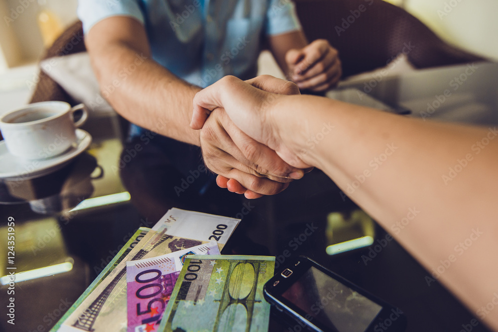Two men shaking hands in cafe Two men shaking hands in cafe