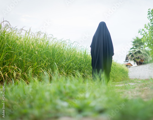 Bild auf Leinwand Beautiful happy Muslim woman in green field
