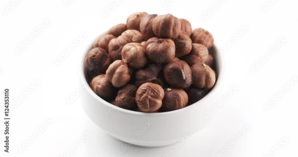organic hazelnuts in bowl on white background loopable rotation video