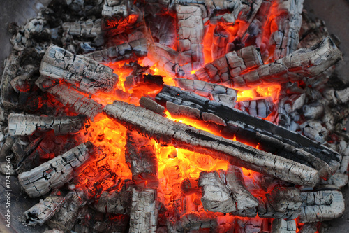 Charred wood and bright flames on dark background