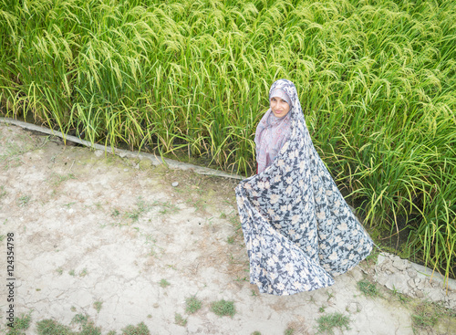 Bild auf Leinwand Beautiful happy Muslim woman in green field