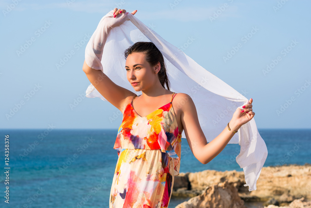 Beautiful sexy woman in a long dress in front of sea veiw.