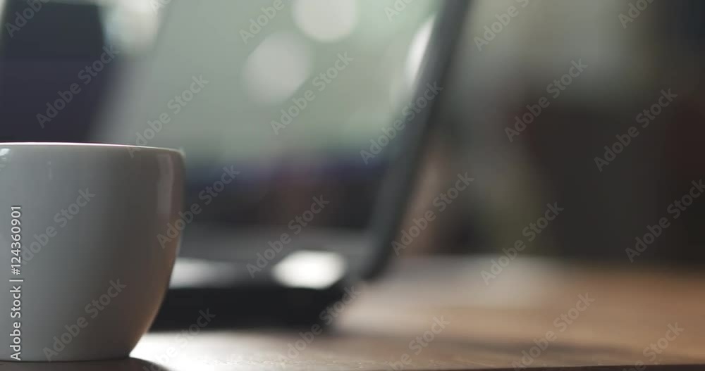 young girl using notebook on a table in cafe and drinking coffee