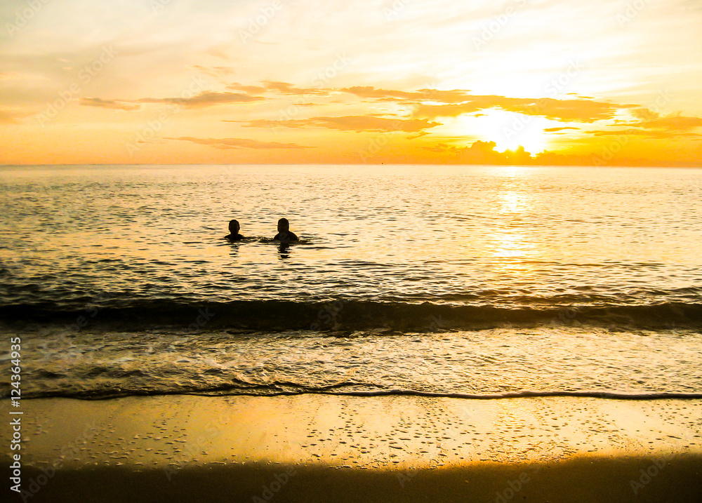 people  on the sea at sunset, silhouette of people having fun together