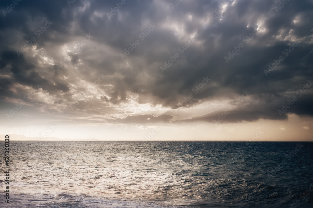 Amazing evening landscape. Stormy ocean with sunset cloudy sky