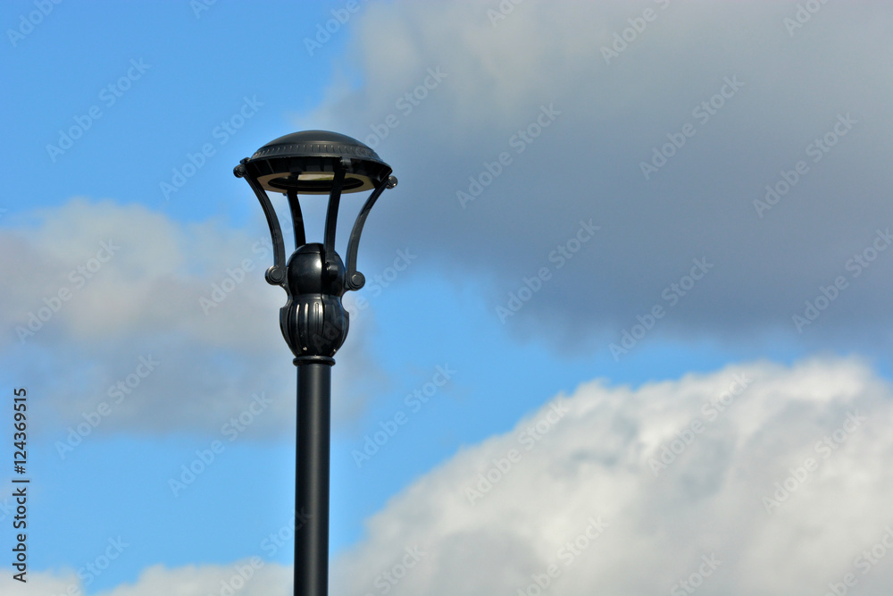 Outdoor lamp post against a cloudy blue sky