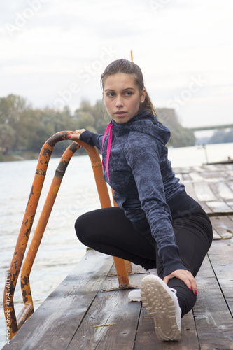 A young woman exercises by the river photo