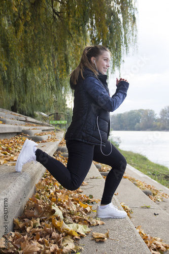 A young woman exercises by the river photo