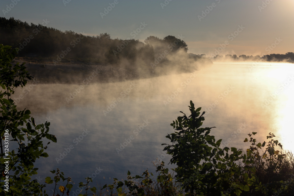 Mist over the river in the rays of the rising morning sun