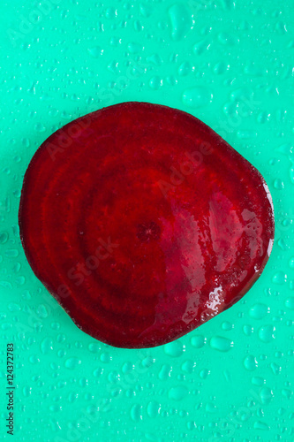 Beet-root. Cross section. Water drops. Green background. Top vie