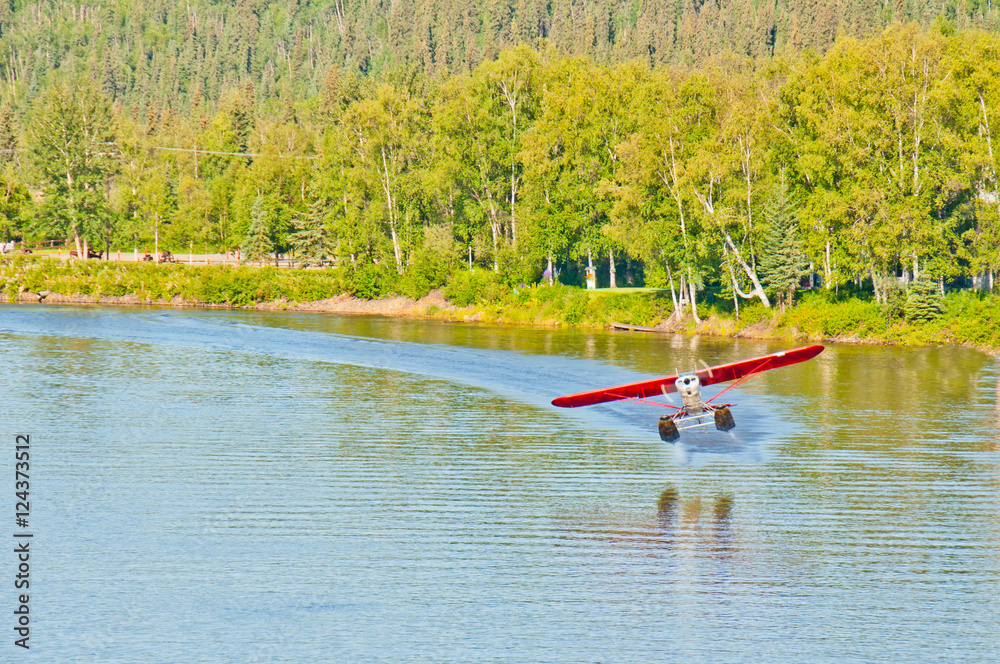 Alaskan float plane takes off from a river.