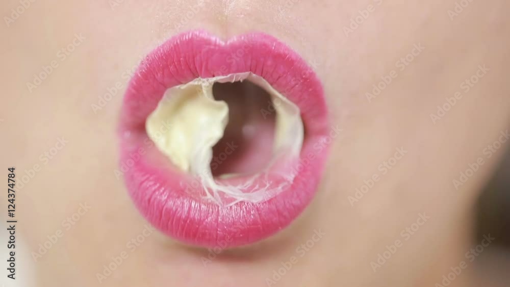 Person doing bubble with chewing gum on bright background