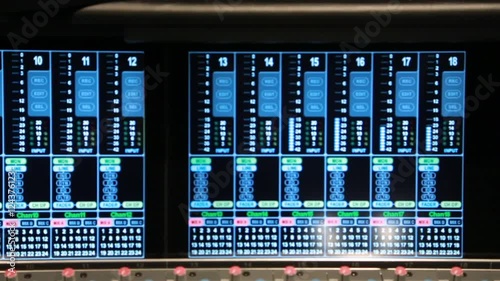 Close up pan of Volume Unit (VU) meters on an audio console in a music studio.