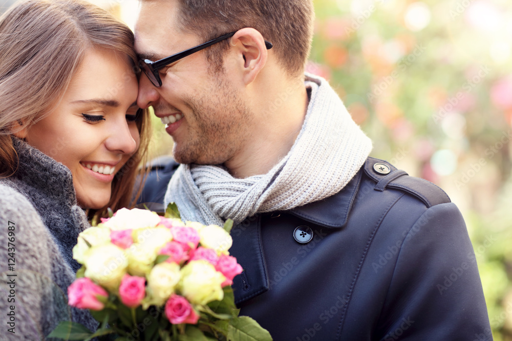 Woman with flowers giving hug to her man Woman with flowers giving hug to her man