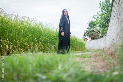 Bild auf Leinwand Beautiful happy Muslim woman in green field