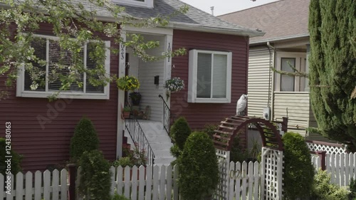 Dolly shot of residential street in spring with cherry blossoms, houses, and fences. photo