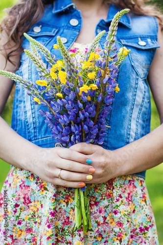 young girl holding a bouquet of wild bright colors