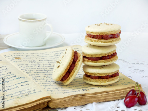 cup of espresso coffee and French macaroons dessert stuffed with cornel on light wooden background