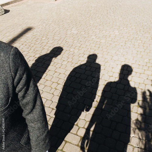 men shadows on street. friends concept
