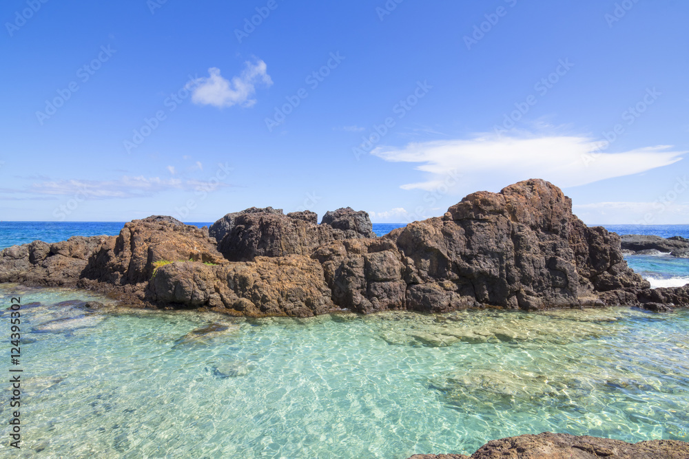 Turquoise pool on rocky tropical sea shore