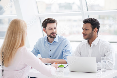 Young coworkers having brainstorming session in modern office