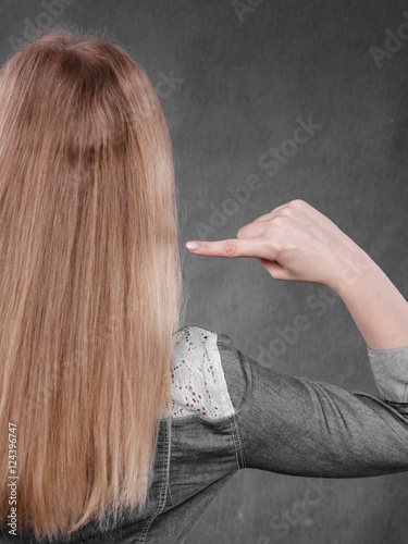 Blonde woman playing with hair.