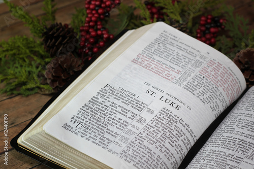 The Bible Opened to The Book of Luke surrounded in Christmas Gar