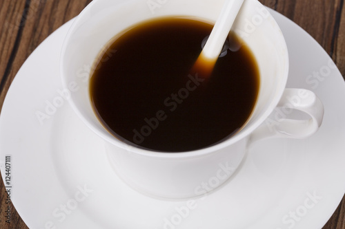 Black coffee closeup on the wooden table background