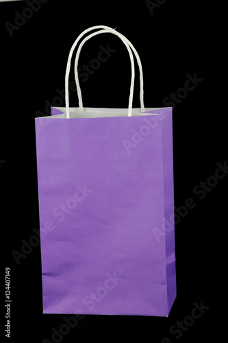 purple paper gift bag isolated on black background