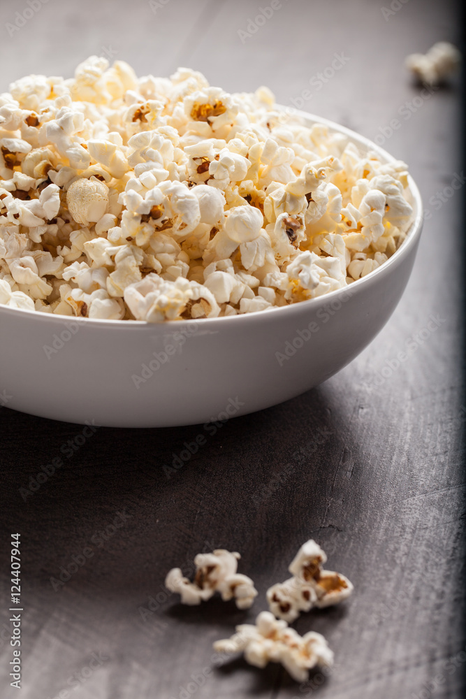 Olive oil popped popcorn in a porcelain bowl side view Olive oil popped popcorn in a porcelain bowl side view