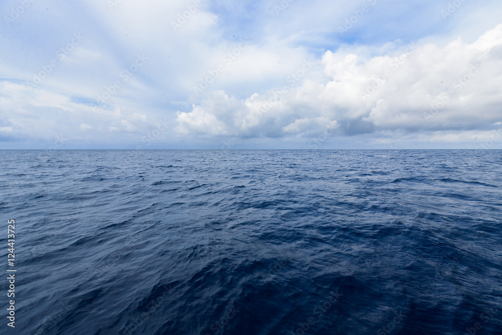 cloudy blue sky on horizon above a deep ocean