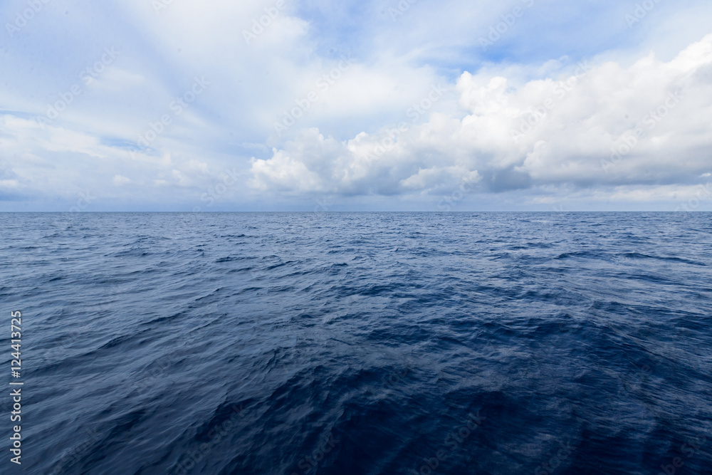 cloudy blue sky on horizon above a deep ocean cloudy blue sky on horizon above a deep ocean