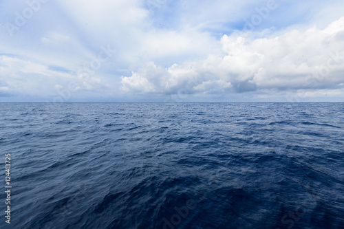 cloudy blue sky on horizon above a deep ocean © Atip R