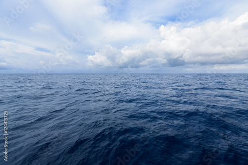 cloudy blue sky on horizon above a deep ocean